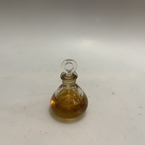 Frasco de vidrio con tapón esmerilado, conteniendo aceite técnico para equipos cinematográficos