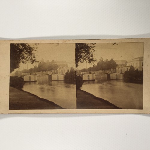 Vista estereo de cartón -Puente sobre un río o canal flanqueado por arboleda y arquitectura clásica europea.