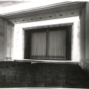 Fotografía: Vista interior del patio de butacas y embocadura del escenario/pantalla de una sala de cine o teatro de época.