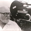 Fotografía en blanco y negro de un operador de cámara junto a una Arriflex 35BLIII