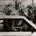 Fotografía de rodaje en blanco y negro mostrando a dos mujeres junto a un coche, década de 1980
