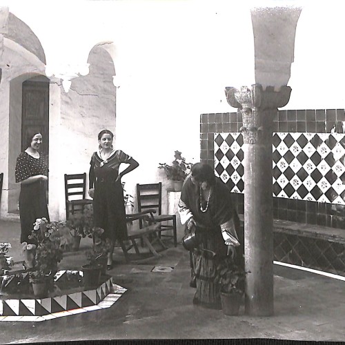 Fotografía en blanco y negro de tres mujeres en un patio andaluz