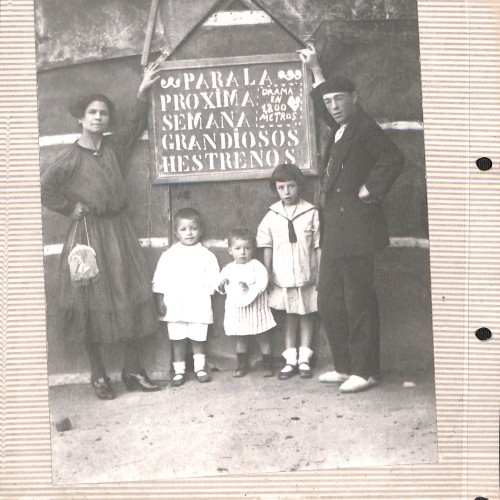 Fotografía costumbrista: familia frente a cartel de cine anunciando 'Hestrenos'