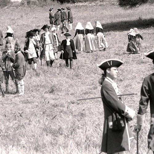 Fotografía en blanco y negro de recreación histórica con personajes vestidos de época