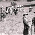 Fotografía en blanco y negro de recreación histórica con personajes vestidos de época