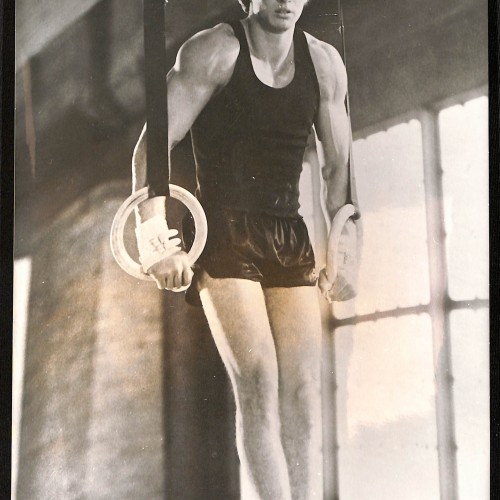 Fotografía publicitaria (lobby card o fotograma de prensa) de la película 'Días rebeldes' mostrando a un gimnasta en anillas