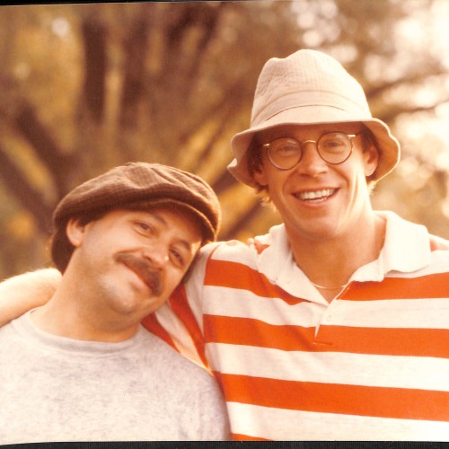 Fotografía en color de dos hombres sonriendo al aire libre