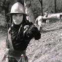 Fotografía en blanco y negro, escena de época con personaje empuñando arma de fuego