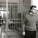 Fotografía en blanco y negro, escena cinematográfica con hombre frente a rejas