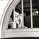 Fotografía en blanco y negro de un joven tras unos barrotes