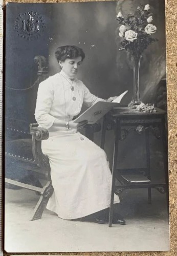 Fotografía señora leyendo apoyada en mesa de Coyne