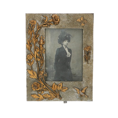 Fotografía de una mujer joven con sombrero con marco de metal